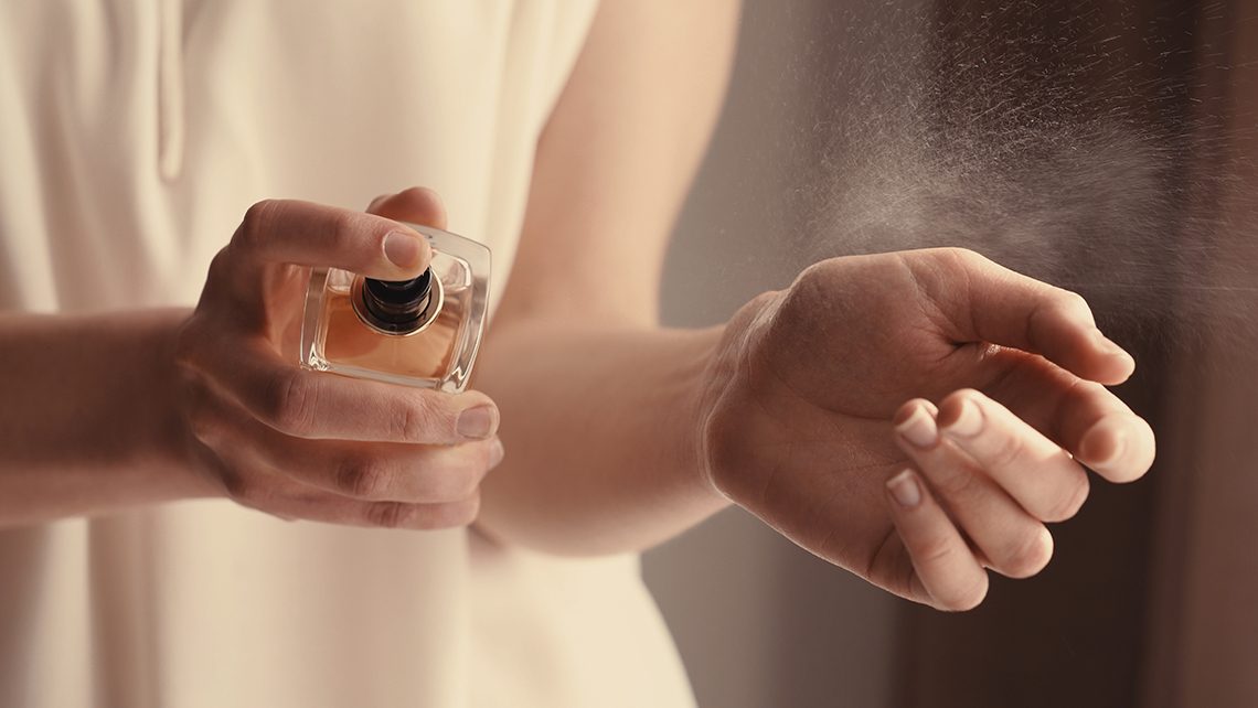 Photo de mains qui se mettent du parfums sur les poignés